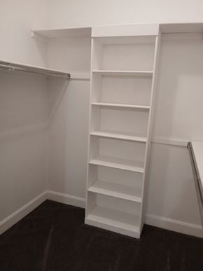 Louisville apartment for rent - A white shelving unit in a room with dark flooring.