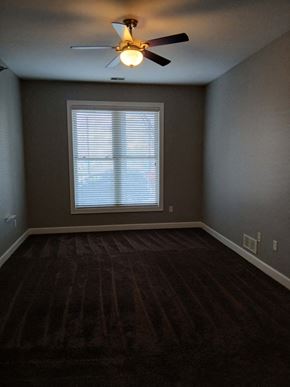 Louisville apartment for rent - A room with a ceiling fan and a window with blinds.