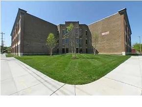 Louisville apartment for rent - A modern building with a curved design and a green lawn in front.
