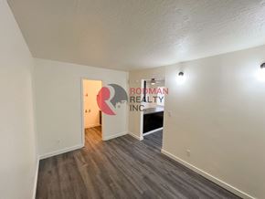 Kelso apartment for rent - A room with a wooden floor and a white wall with a doorway leading to another room.