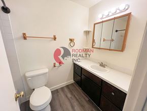 Kelso apartment for rent - A white toilet sits in a bathroom with a wooden cabinet and a mirror above it.