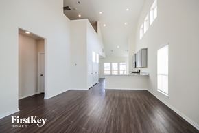 Humble house for rent - A spacious room with wooden floors and white walls.