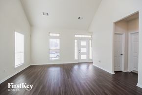 Humble house for rent - A spacious room with wooden floors and white walls.