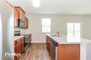 Jacksonville house for rent - A kitchen with wooden cabinets and a marble countertop.