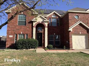 Mansfield house for rent - a red brick house with a black door and a white garage