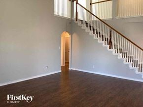 Mansfield house for rent - an empty living room with a staircase and a door to a hallway