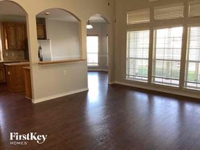 Mansfield house for rent - an empty living room and kitchen with wood floors