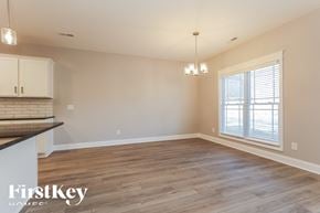 Clarksville house for rent - A spacious room with wooden flooring and a window with blinds.