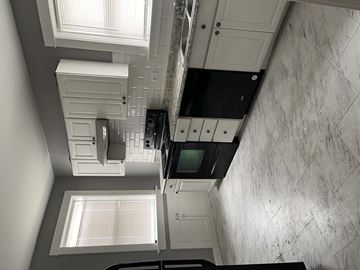 Saint Louis apartment for rent - A kitchen with a black oven and white cabinets.