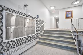 Montréal apartment for rent - A staircase with a metal railing and a wall with a black and white patterned tile.