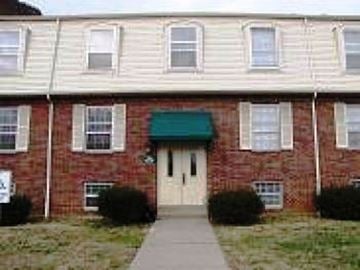 Louisville apartment for rent - a red brick house with a green roof and white doors