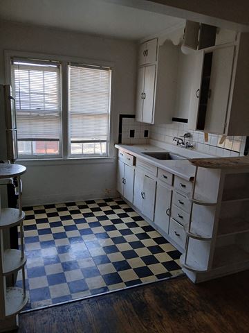 Louisville apartment for rent - a kitchen with a checkered floor and a sink and a window