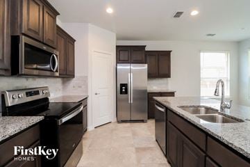 Waxahachie house for rent - A kitchen with brown cabinets and a stainless steel refrigerator.