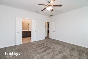 Waxahachie house for rent - A spacious room with a carpeted floor and a ceiling fan.