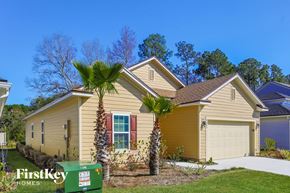 Jacksonville house for rent - a yellow house with palm trees in front of it