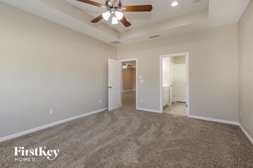 Jacksonville house for rent - a spacious living room with carpet and a ceiling fan