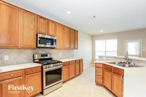 Cypress house for rent - a kitchen with wooden cabinets and stainless steel appliances