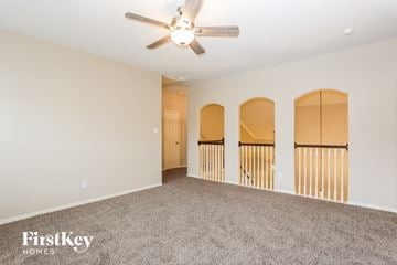Cypress house for rent - a spacious living room with carpet and a ceiling fan