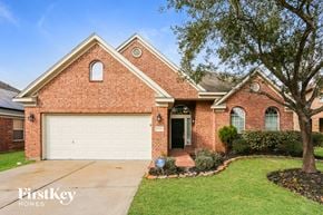 Cypress house for rent - a brick house with a white garage door