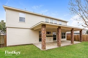 Cypress house for rent - the exterior of a white house with brick pillars and a porch