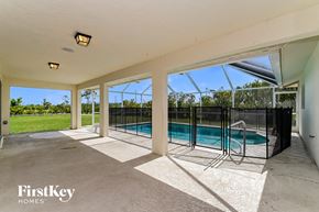 Cape Coral house for rent - a patio with a pool and a wrought iron fence