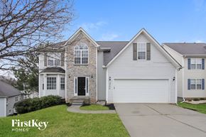 Charlotte house for rent - a white house with a stone facade and a white garage door