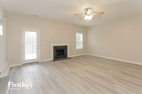Charlotte house for rent - a living room with a fireplace and a ceiling fan