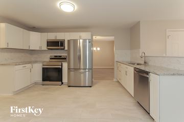 Charlotte house for rent - a large kitchen with white cabinets and stainless steel appliances