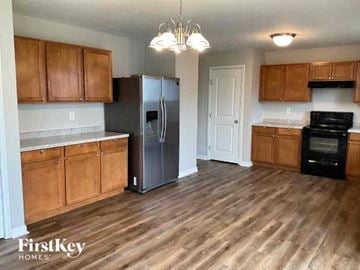 Blacklick house for rent - a kitchen with wooden cabinets and a stainless steel refrigerator