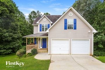 Dawsonville house for rent - a house with a white garage door and blue shutters