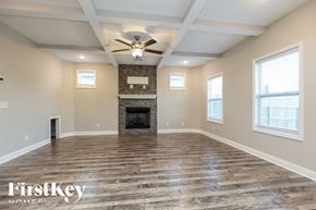Clarksville house for rent - A spacious room with a fireplace and wood flooring.