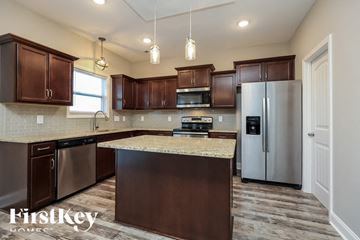Clarksville house for rent - A kitchen with brown cabinets and a granite countertop.