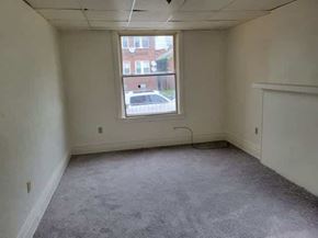 Homestead apartment for rent - A room with a window and a view of a street and buildings outside.