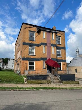 Homestead apartment for rent - A red awning is on the front porch of a brick building.