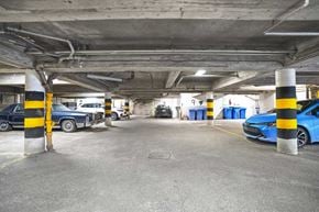 Montréal apartment for rent - A parking garage with a blue car parked in the foreground.