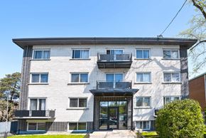 Montréal apartment for rent - A modern building with a black gate and a balcony on the second floor.