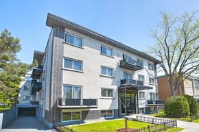 Montréal apartment for rent - A modern apartment building with a black fence in front.