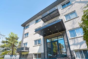 Montréal apartment for rent - A modern building with a black awning and glass doors.