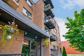 Montréal apartment for rent - A red brick building with a balcony and a sign that says 6161.