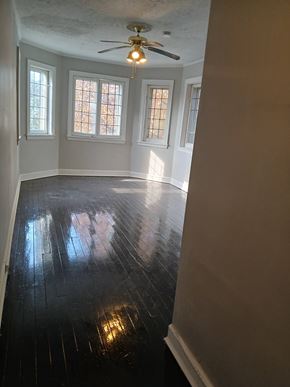 Louisville apartment for rent - A room with a ceiling fan and three windows.