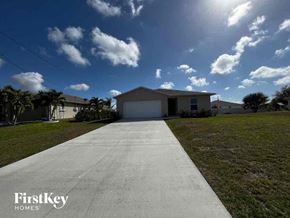 Cape Coral house for rent - a house with a white garage door on the side of a driveway