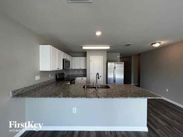 Cape Coral house for rent - a kitchen with a granite counter top and a sink