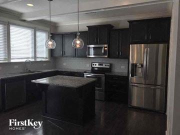 Pineville house for rent - A kitchen with black cabinets and stainless steel appliances.