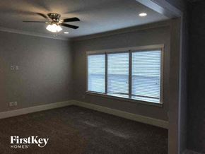 Pineville house for rent - A room with a carpet floor, a ceiling fan, and a window with blinds.