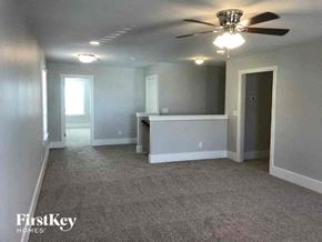 Pineville house for rent - A spacious room with a ceiling fan and carpeted floor.