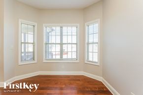 Clarksville house for rent - A room with wooden floors and three windows.