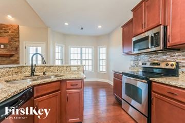 Clarksville house for rent - A kitchen with brown cabinets and a stone wall.