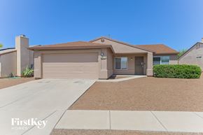 Tucson house for rent - A house with a brown roof and a garage door is for sale.
