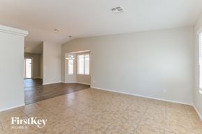 Tucson house for rent - A spacious room with a tiled floor and a window with blinds.