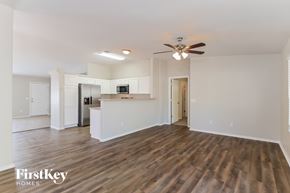 Tucson house for rent - A spacious living room with wooden flooring and a ceiling fan.